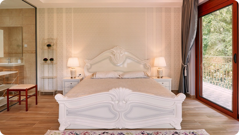 Elegante camera da letto di lusso con un letto bianco decorativo, lampade da comodino eleganti e accesso a una terrazza privata.