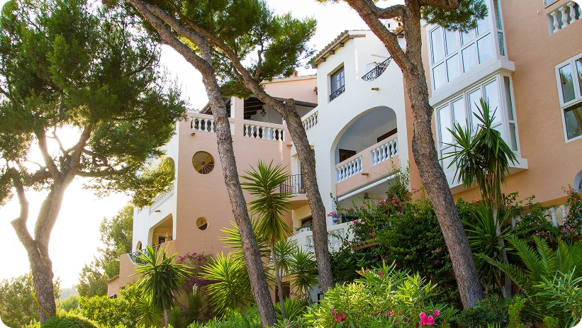 Elegante hotel in stile mediterraneo circondato da giardini lussureggianti, pini maturi e paesaggi vibranti, offrendo un'atmosfera di resort tranquilla.